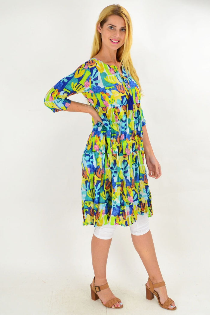 One Summer Great Barrier Reef tie neck tunic dress displayed on a hanger, showcasing its vibrant pattern and relaxed fit.