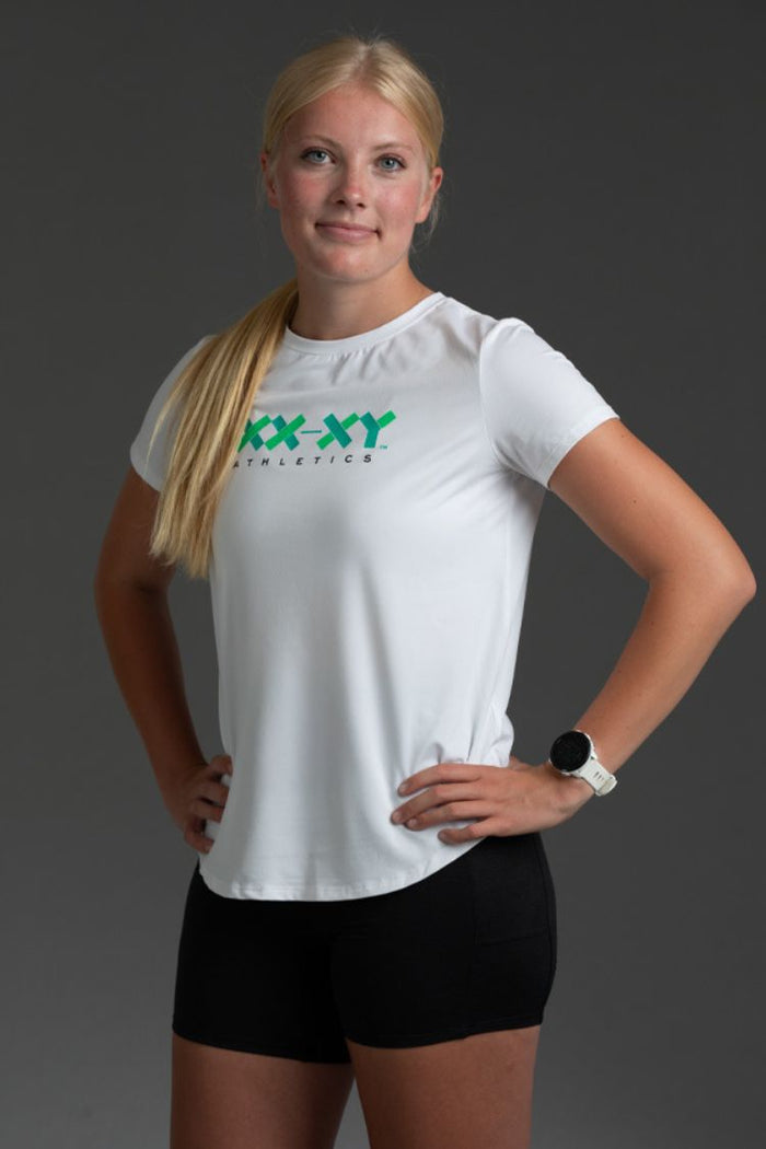 Woman wearing a white t-shirt with 'XX-XY Athletics' logo on a gray background || Black/Dark Heather Gray/White