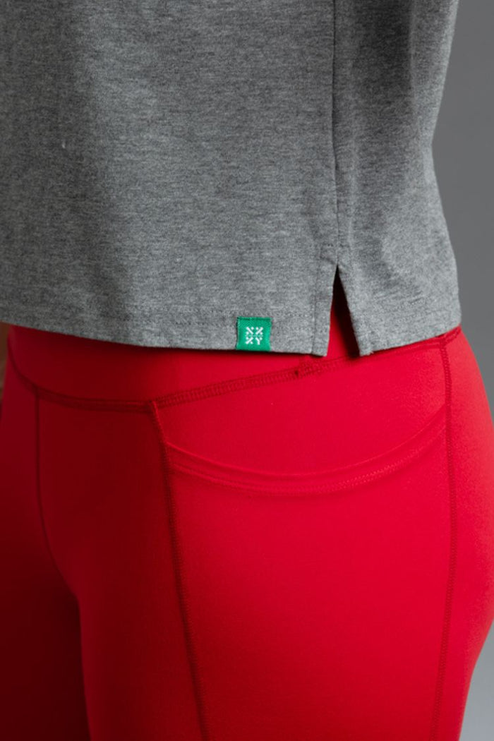 Gray sweatshirt and red pants with a green logo tag on a gray background || RED