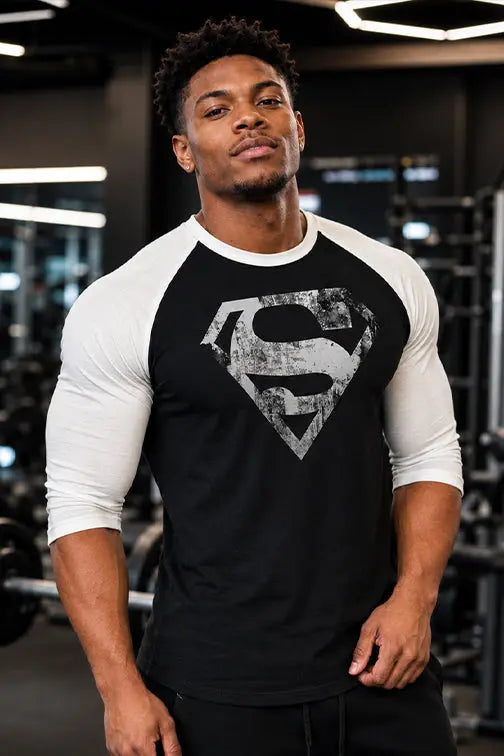 Man wearing a black and white Superman shirt in a gym setting